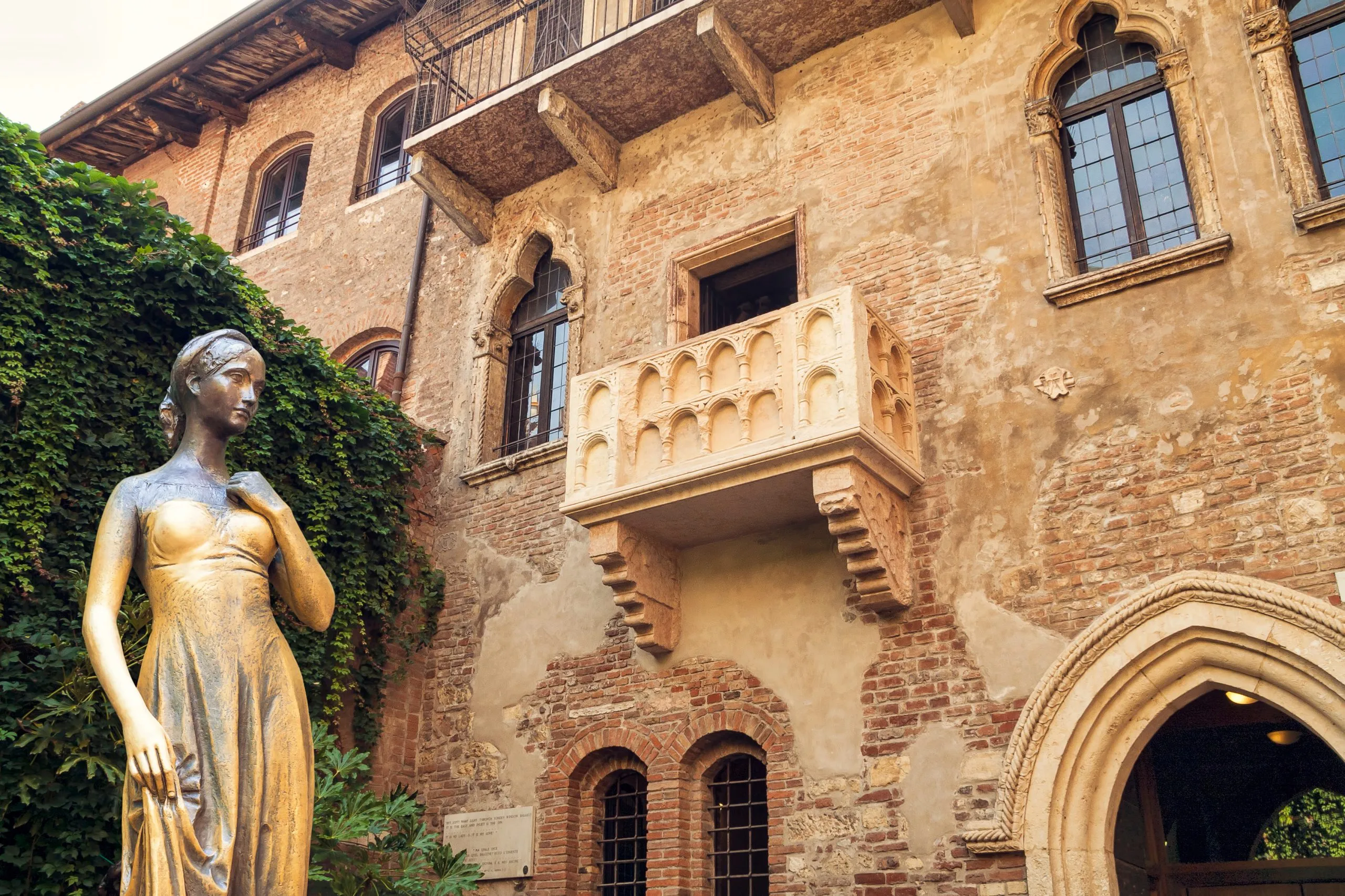 Bronzen standbeeld van Julia en balkon bij het huis van Julia, Verona, Italië.